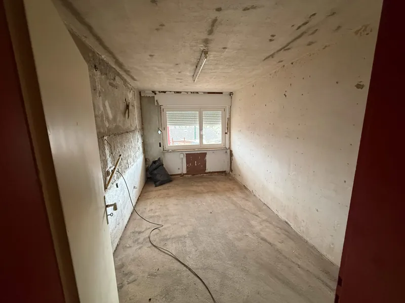 Langer Raum nach der Entkernung, Fliesenkleber an der Wand