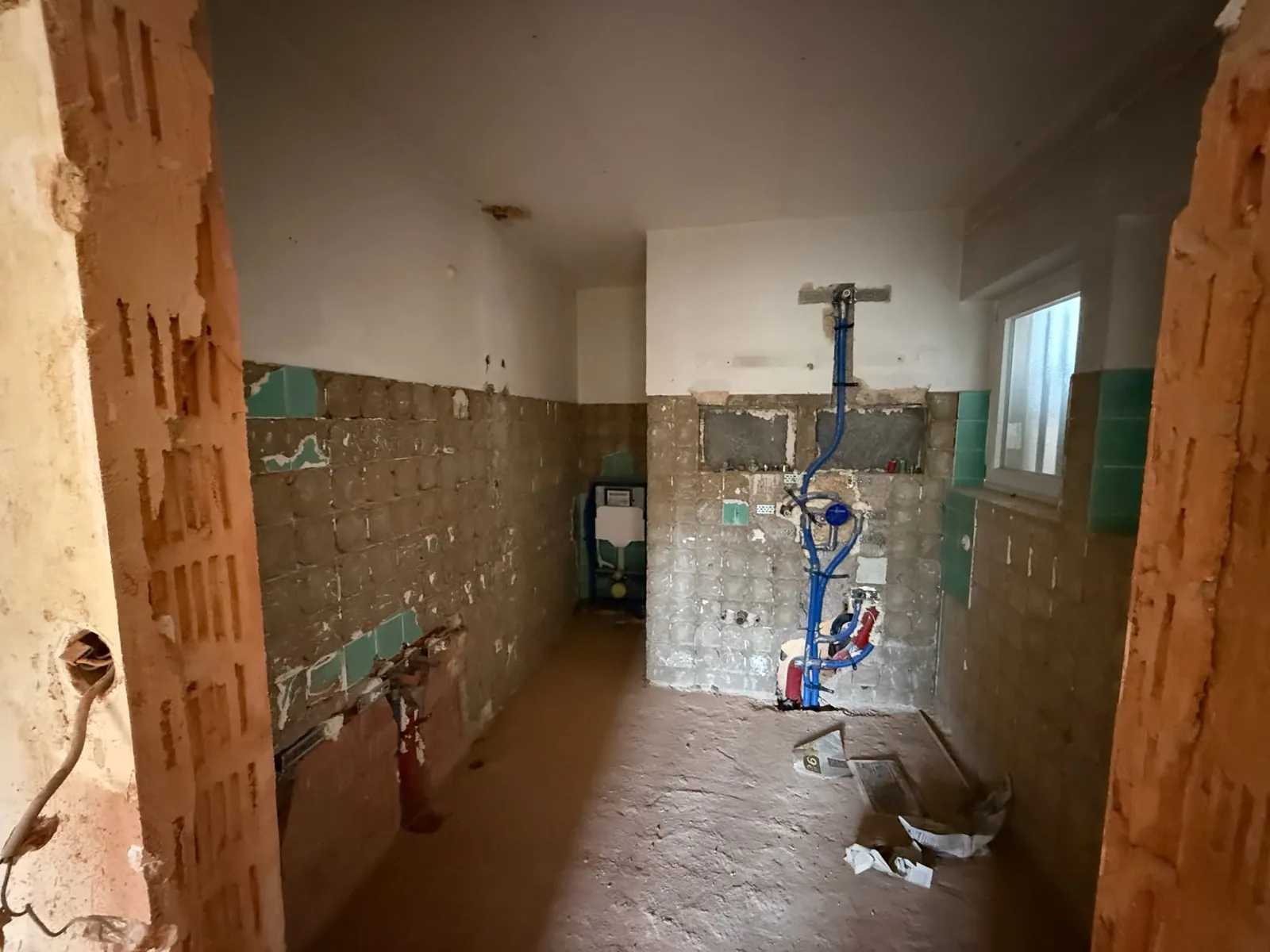 Nachher: Badezimmer zurückgebaut, Fliesen entfernt, Anschlüsse frei